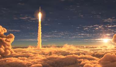 Rocket launching about clouds with sun behind.