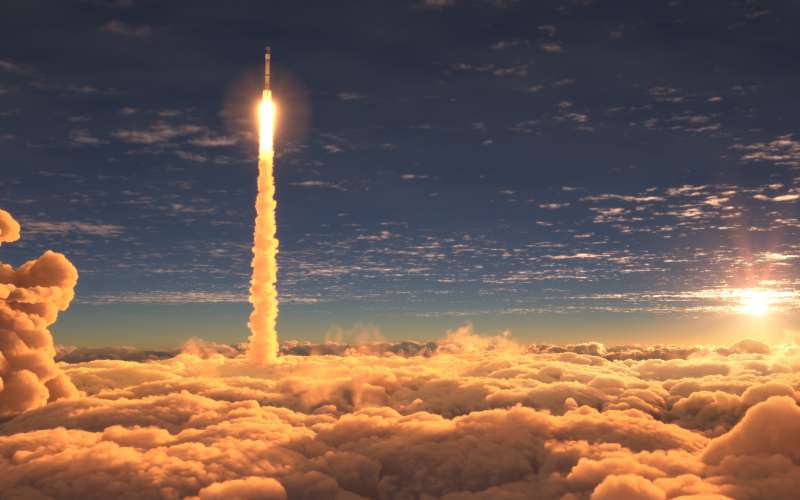 Rocket launching about clouds with sun behind.