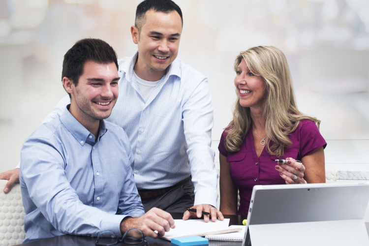 Picture of group collaborating around a laptop