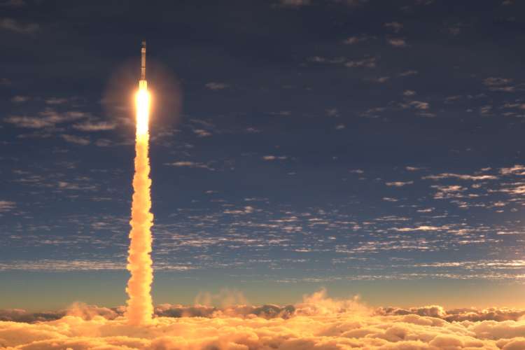 Rocket launch above clouds at sunset