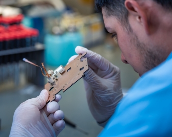 Technician working on part for the NIRAC satellite. 